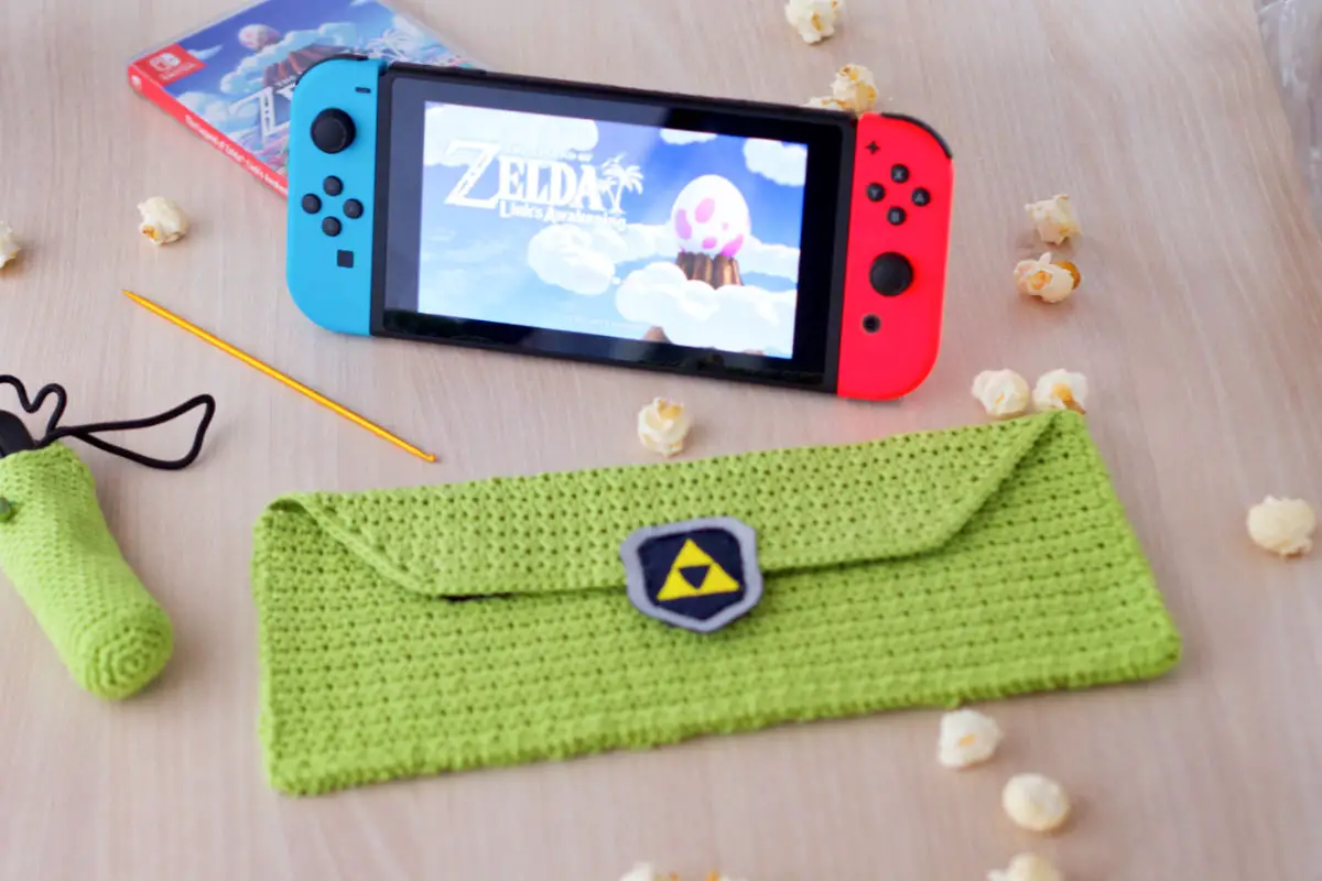 Nintendo Switch mit Zelda Startbildschirm und gehäkelter grüner Tasche