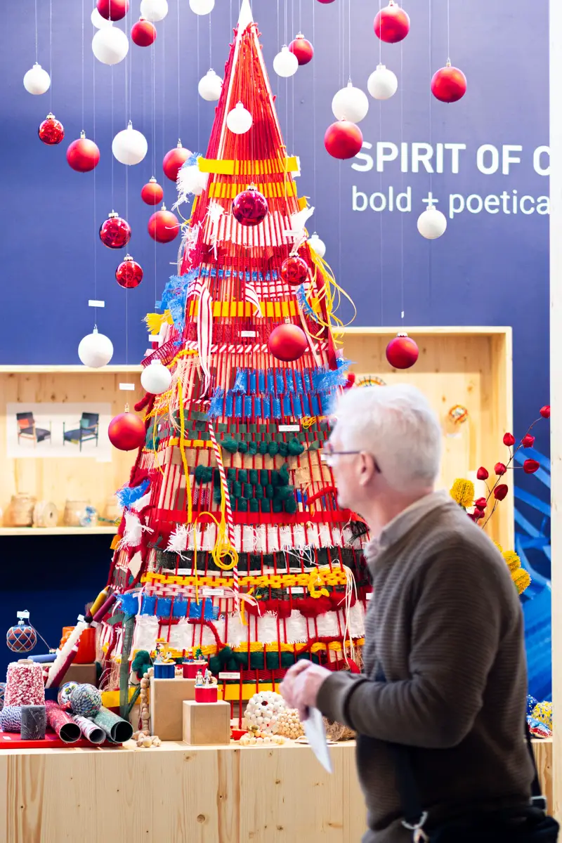 Ein Mann steht vor einem kreativen Weihnachtsbaum.